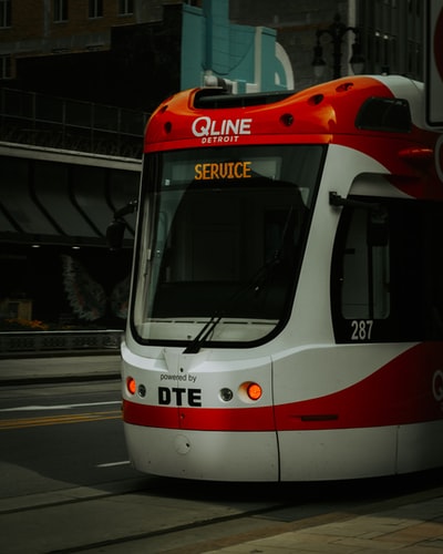 white and red train on the street during daytime